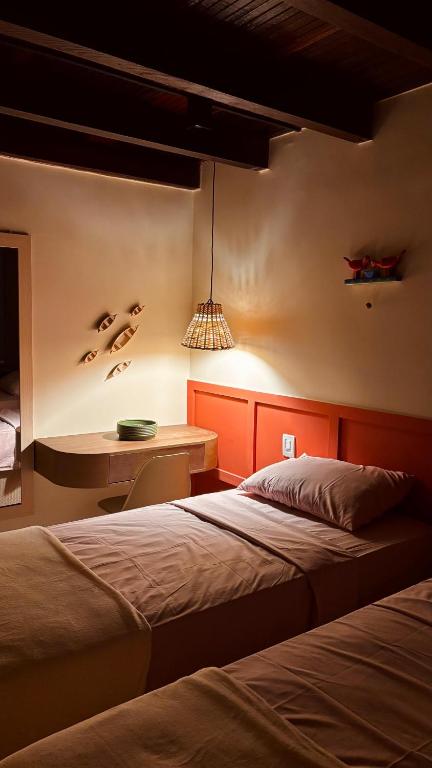 a bedroom with two beds and a desk in it at Casa 678 in Belém