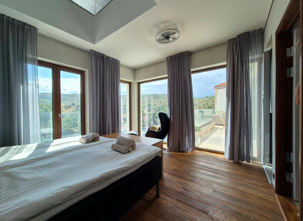 a bedroom with a large bed and large windows at Apartment Oliven Penthouse in Sutivan