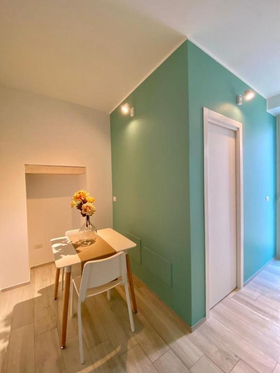 a dining room with a table and a green wall at B&B Iris in Terlizzi