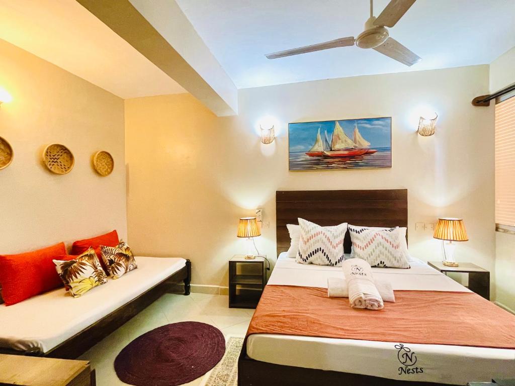 a bedroom with two beds and a couch at Executive Tamarind Nest in Ukunda