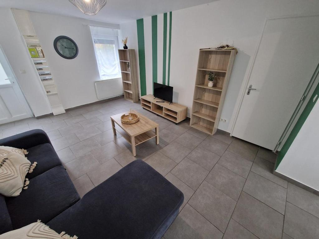 a living room with a couch and a table at Spacieux 3 chambres Tout équipé in Feignies