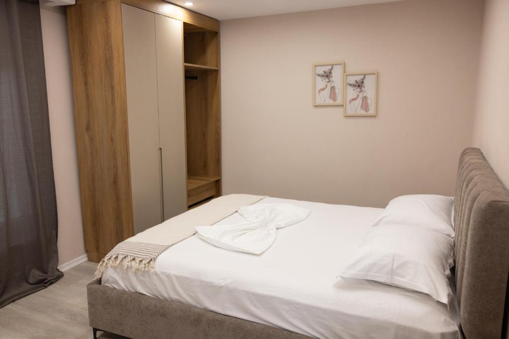a bedroom with a bed with white sheets at 3 Min To Center Stylish Stay's in Tirana