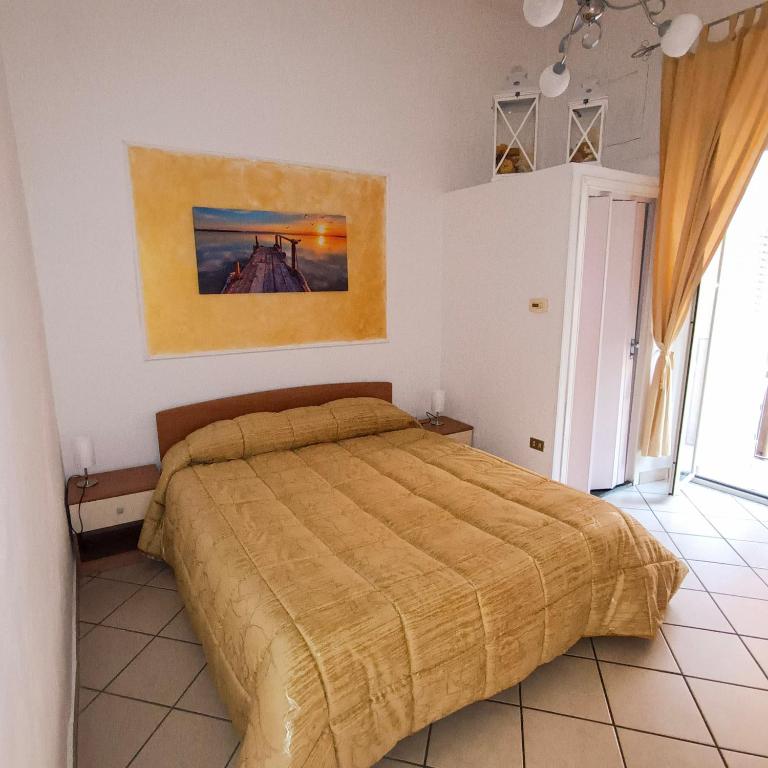 a bedroom with a bed and a painting on the wall at Appartamento GG - Palmi in Palmi