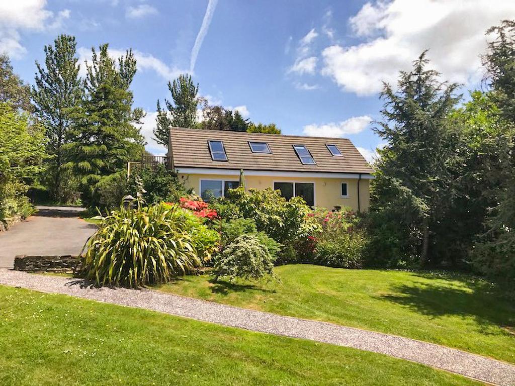 a house with solar panels on top of a yard at The Aviary-Uk44382 in Callington