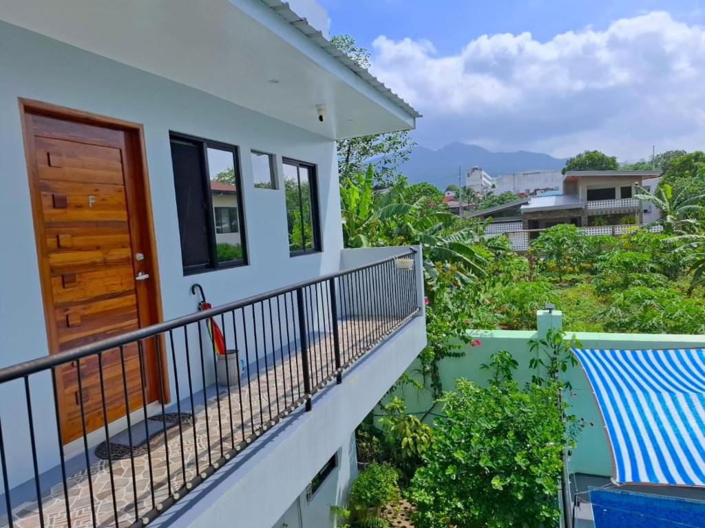 a balcony of a house with a wooden door at Bleu Saphire Apartments in Los Baños