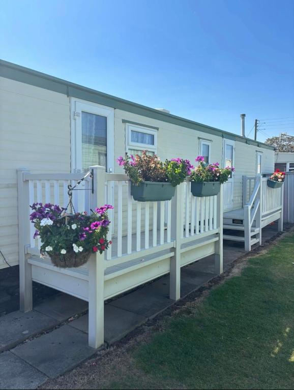 a mobile home with two flower pots on a fence at KC Caravans in Ingoldmells