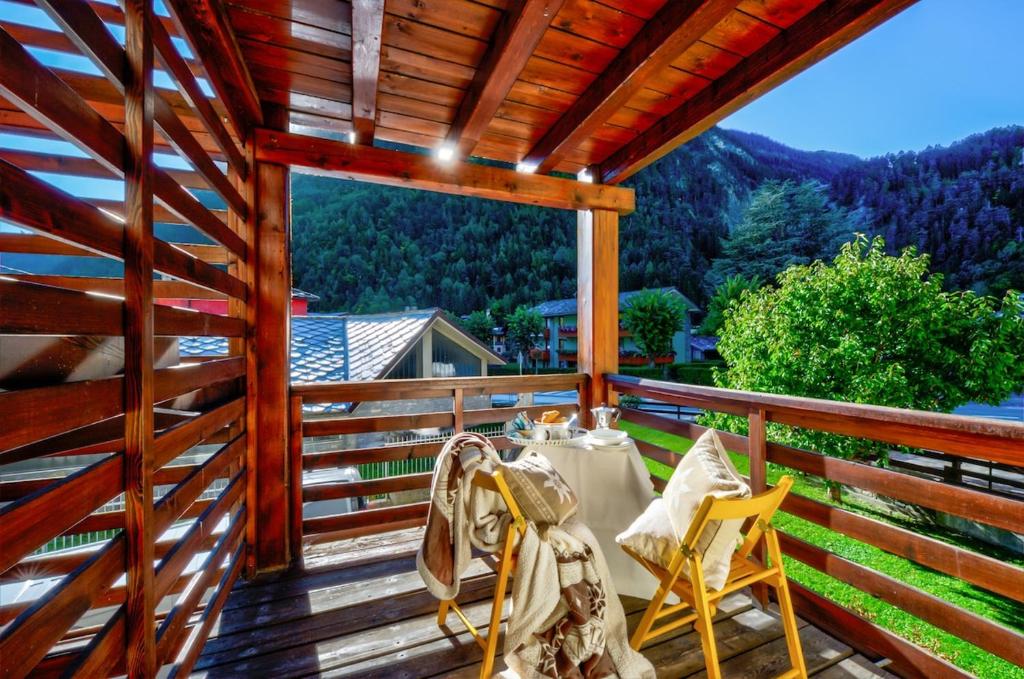 a patio with a table and chairs on a wooden deck at Genziana in Pré-Saint-Didier