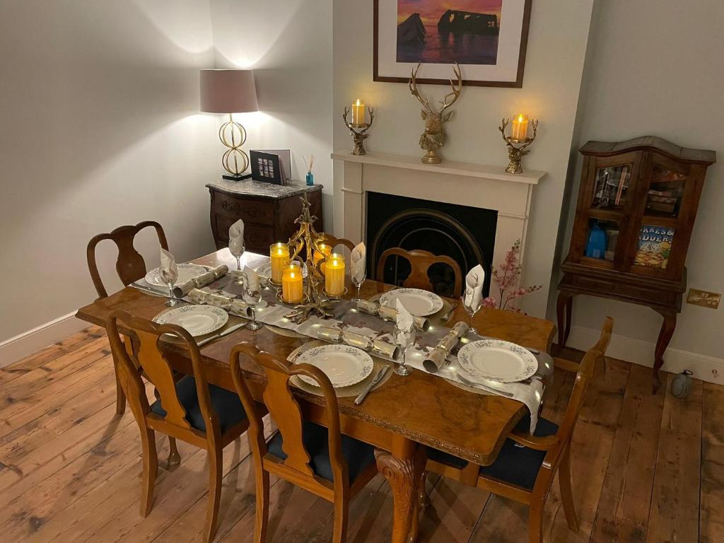 een eetkamer met een tafel en stoelen en een open haard bij Luxury pair of Georgian apartments, hot tub, sea views, sleeps 12 in Bognor Regis