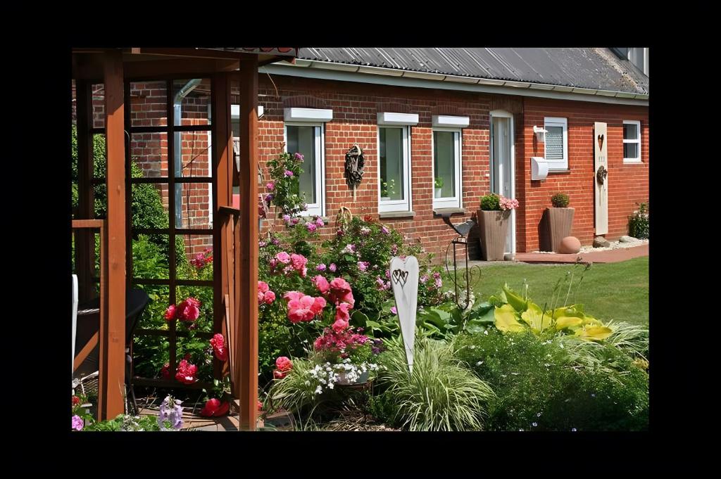 a garden with flowers in front of a house at Ferienhaus Nanny Und Helene in Uphusum