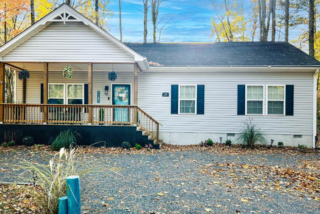 a white house with a porch with a deck at 28 White Horse Dr, Ocean Pines, MD 21811 in Ocean Pines
