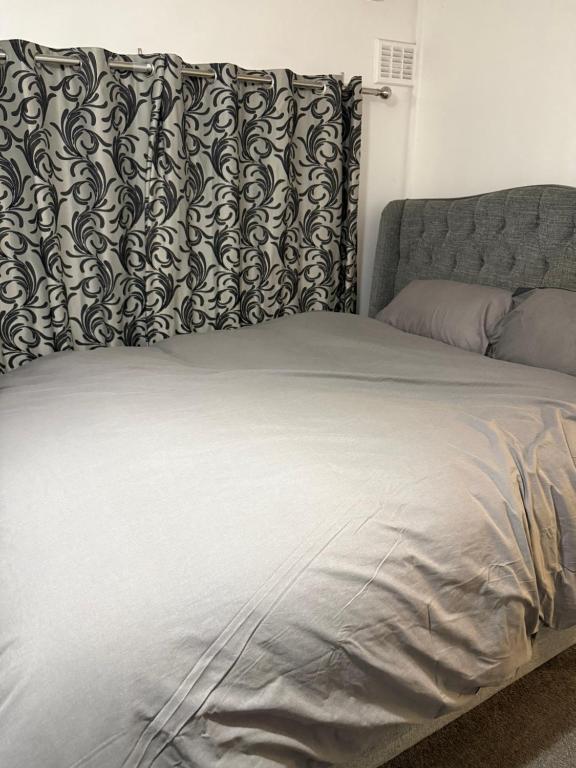 a large bed with a black and white pillow on it at Belexsia Guest House in Stoke on Trent