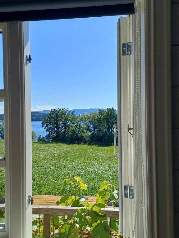 an open window with a view of a field at Lovely tiny house with a dream view ! in Østdal