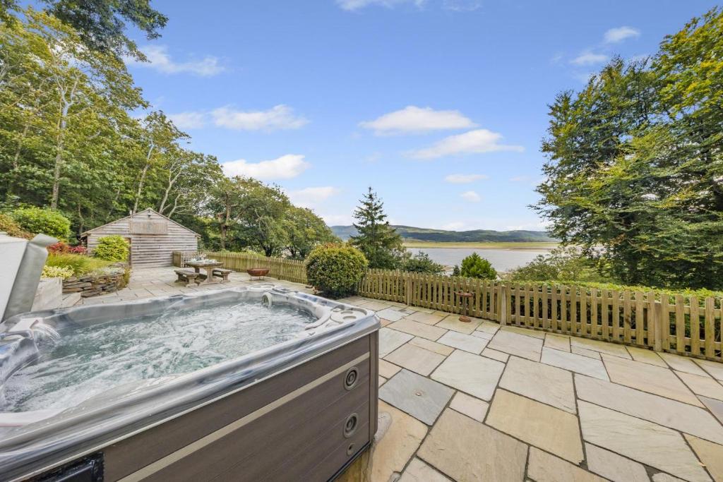 a hot tub on a patio next to a fence at 4 Bed in Aberdovey oc-p33131 in Scyborycoed