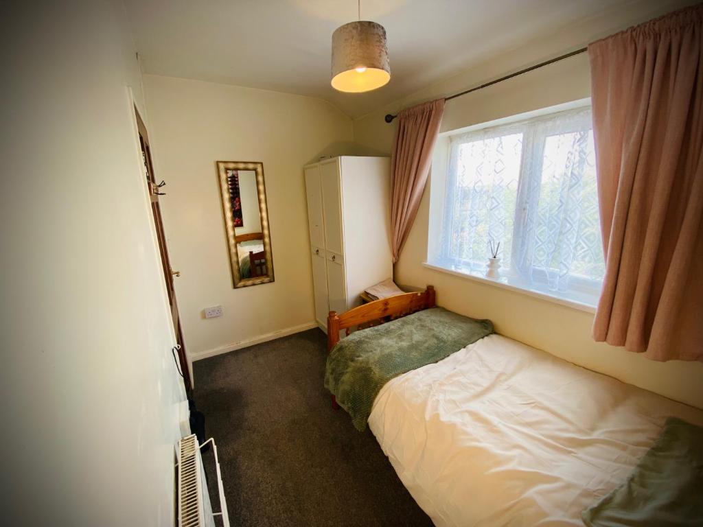 a small bedroom with a bed and a window at Modern-privateGarden-Family-20MinToLDN in Stevenage