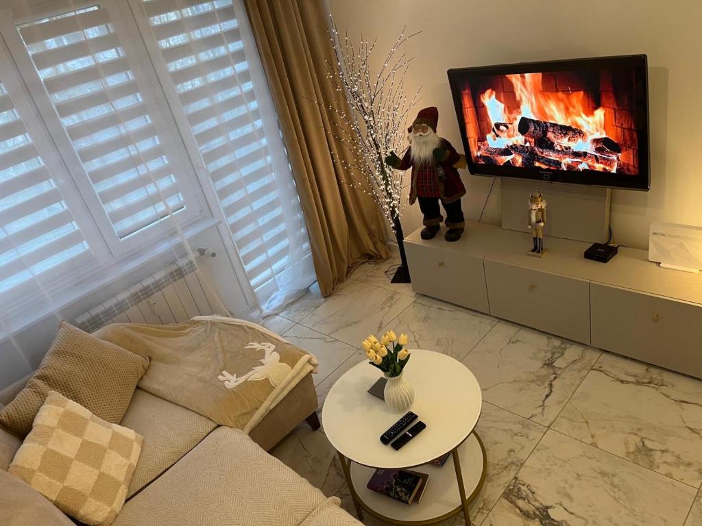 a living room with a couch and a tv at Sara Apartament in Turek