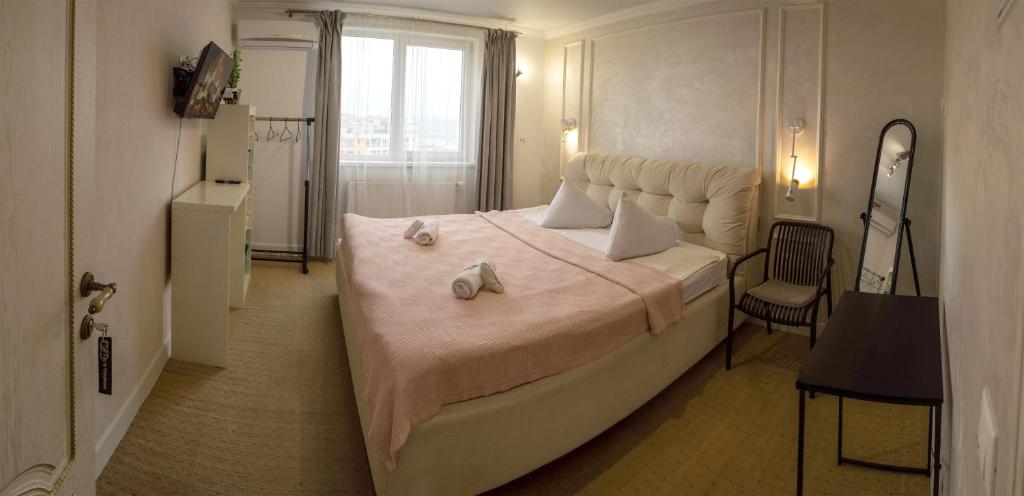 a bedroom with a large bed with towels on it at Двухместная комната общая ванная, Double Room Shared Bathroom in Chişinău