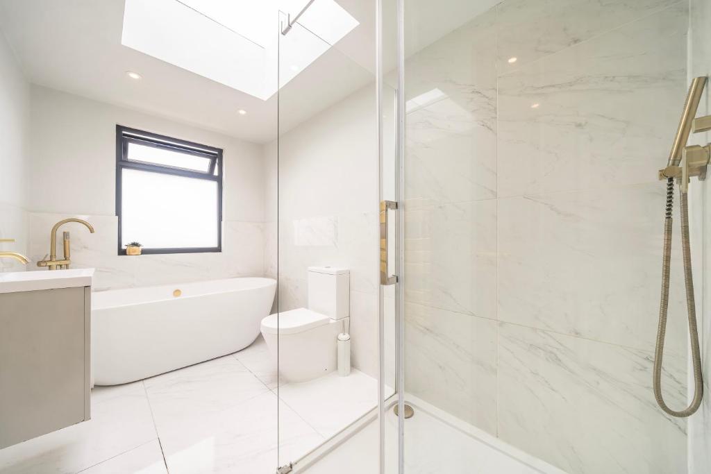 Un baño con ducha, bañera y lavabo. en Juliet balcony room, en Lower Sydenham Station