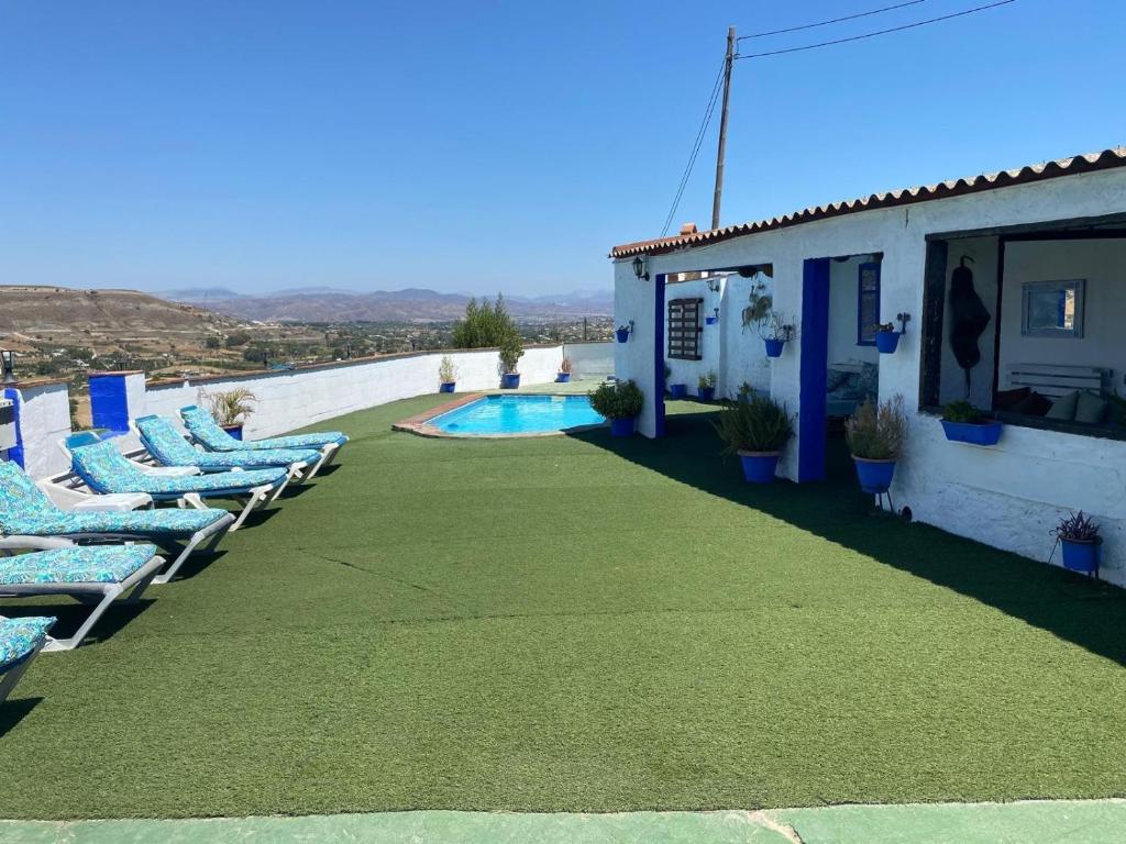 eine Terrasse mit Liegestühlen und ein Swimmingpool in der Unterkunft Cortijo rural los Erales in Alhaurín el Grande