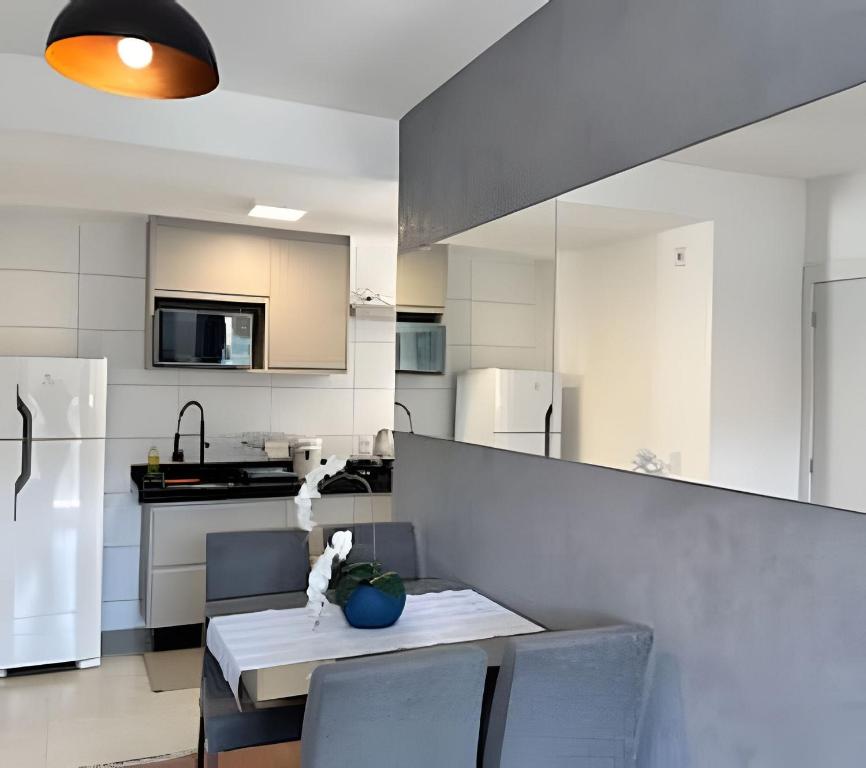 a kitchen with a table and chairs and a kitchen with white appliances at Denny Prime Loft - Executive Apartment in Extrema in Extrema