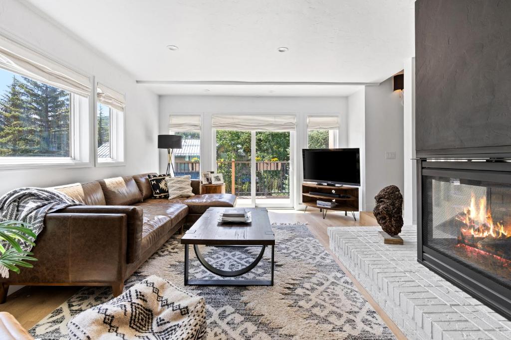 a living room with a couch and a fireplace at Modern Alpine Retreat at Vail in Vail