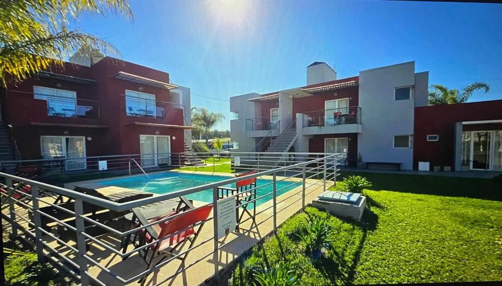 a house with a swimming pool in front of a building at 5 SOLES CHAJARI in Chajarí