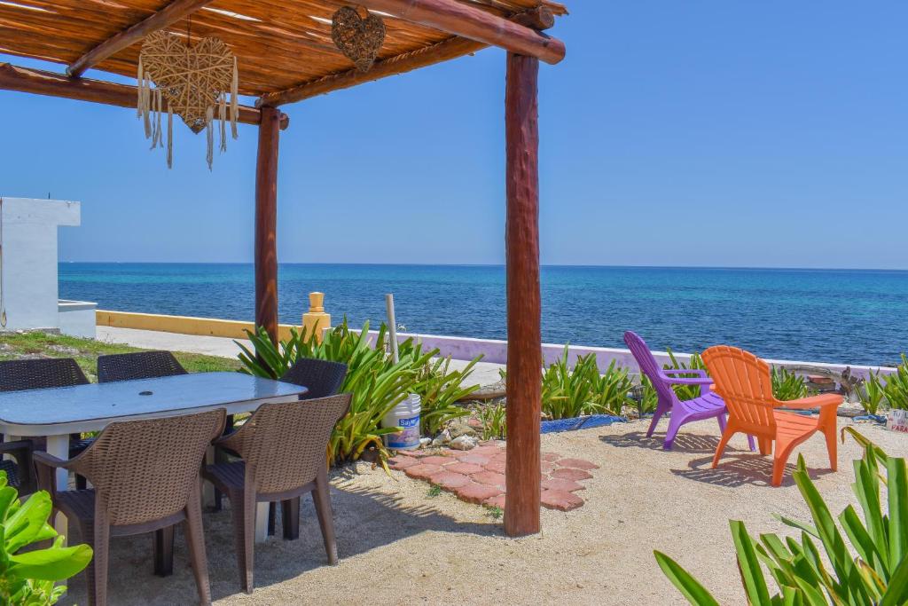 a patio with a table and chairs and the ocean at "Casitas Arcoiris" Excelente ubicación - Petfriendly in Isla Mujeres