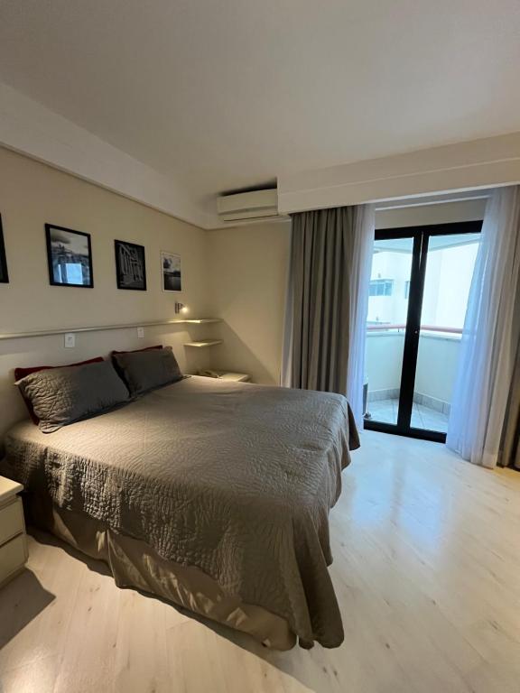 a bedroom with a bed and a large window at Hotel Sena Madureira Ibirapuera Com Garagem 1210 in Sao Paulo