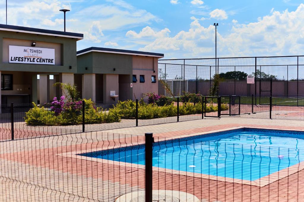 a swimming pool in front of a building at Cozy 1-Bed Apartment in Gaborone in Gaborone