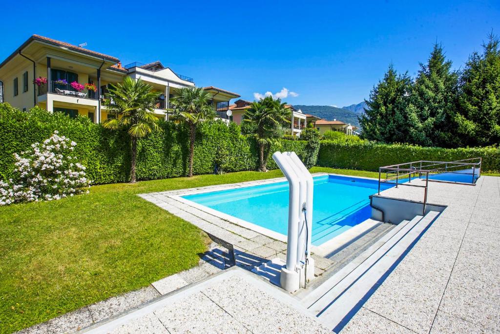 a swimming pool in a yard next to a house at Residenz La Vela in Baveno