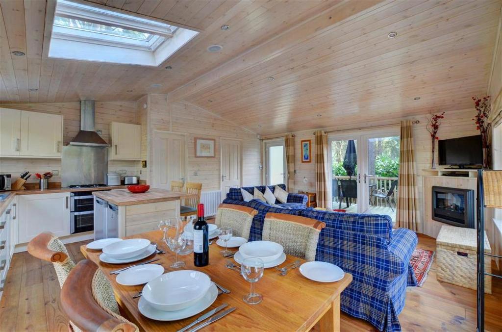 ein Esszimmer und ein Wohnzimmer mit Tisch und Stühlen in der Unterkunft Milliners Lodge in Kelling