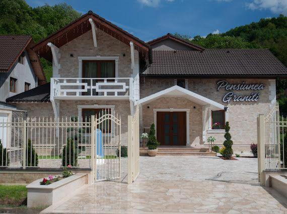 una casa con una puerta delante de ella en Pensiunea Graniti, en Lunca