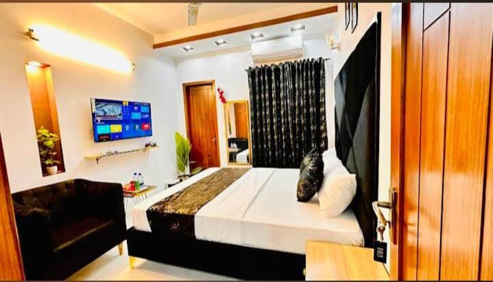 a bedroom with a bed and a television in it at Airport Gateway Guesthouse in Rawalpindi