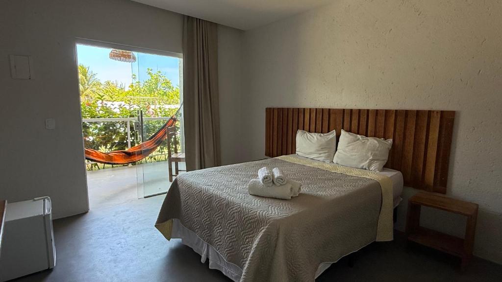 a bedroom with a bed with two towels on it at Pousada Pé na Areia in São Miguel dos Milagres