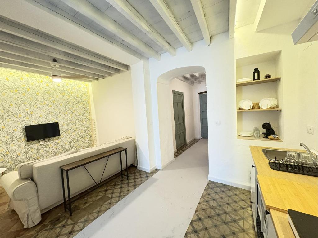 a living room with a couch and a tv on a wall at La Clara Domus in Seville