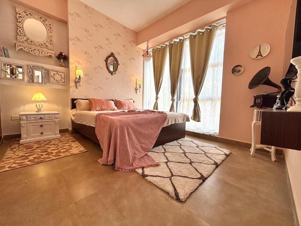 诺伊达Paris Style Luxe Apartment In The Heart Of Noida的一间卧室，配有一张床、一张桌子和一扇窗户