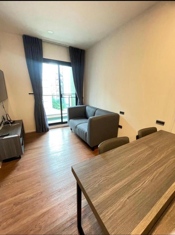a living room with a couch and a table at The Central Escape Phuket in Ban Rangeng