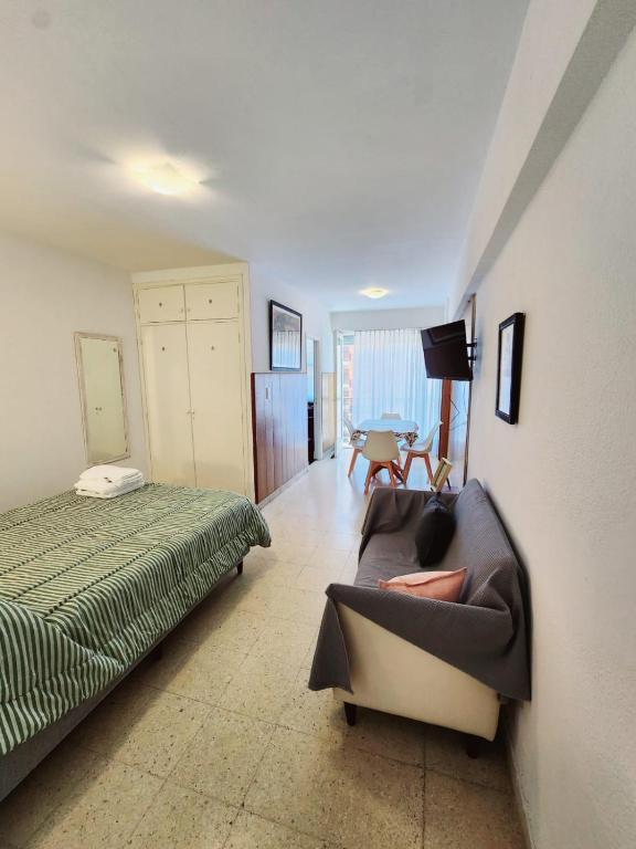ein Schlafzimmer mit einem Bett, einer Couch und einem Tisch in der Unterkunft Monoambiente y sala de estar con garage in Mar del Plata