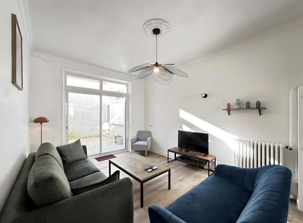 BéthenyDiouf House的客厅里有一张蓝色沙发和一台电视