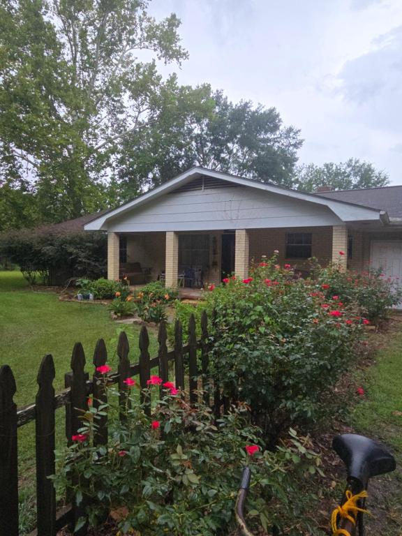 uma casa com cerca e flores no quintal em Waterloo Farms em Hattiesburg