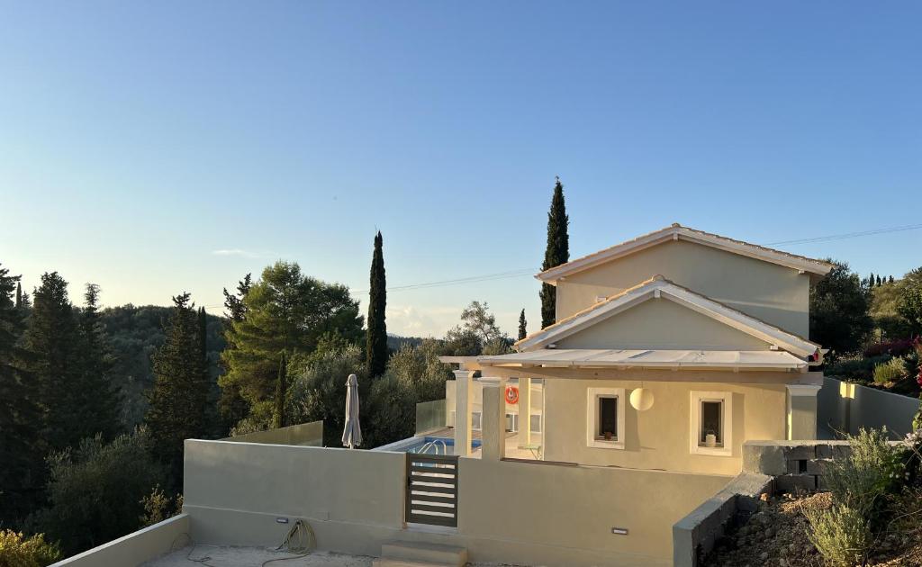 a house sitting on top of a hill at Giardinia Holiday Homes with Private Pool in Gazátika
