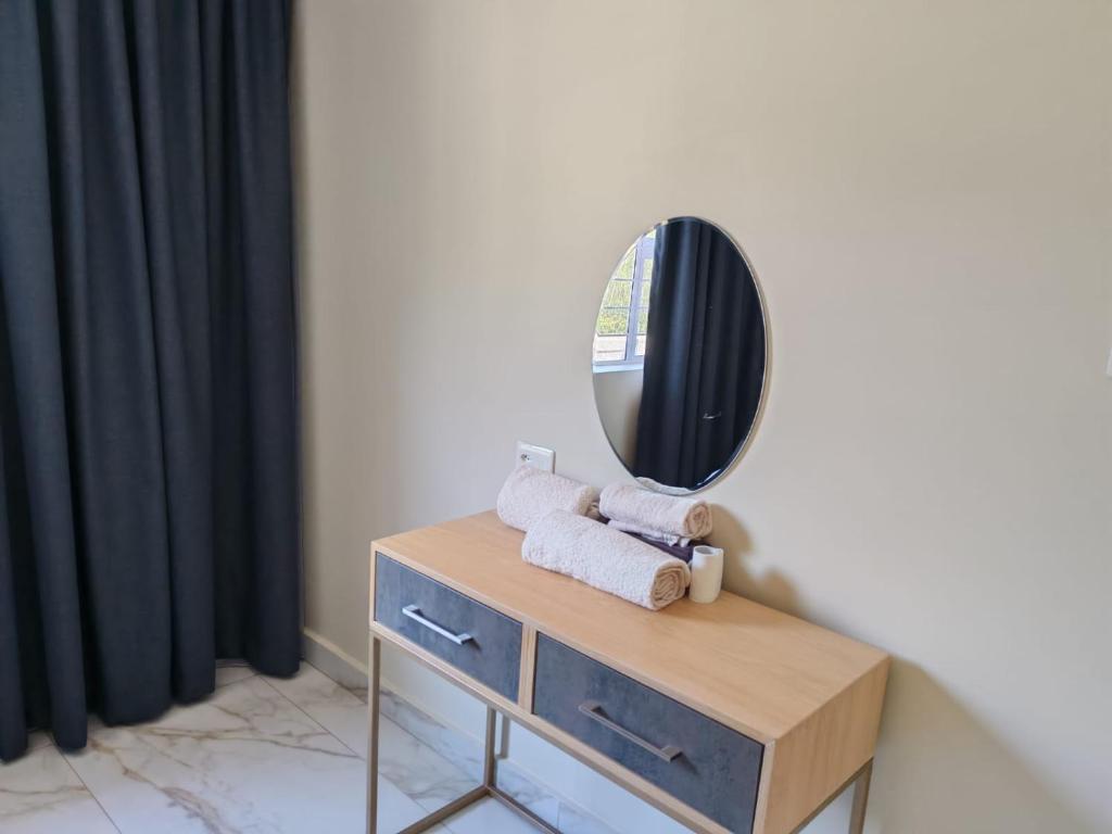 a mirror on top of a dresser with towels at Modern Beachfront Escape in La Mercy in La Mercy