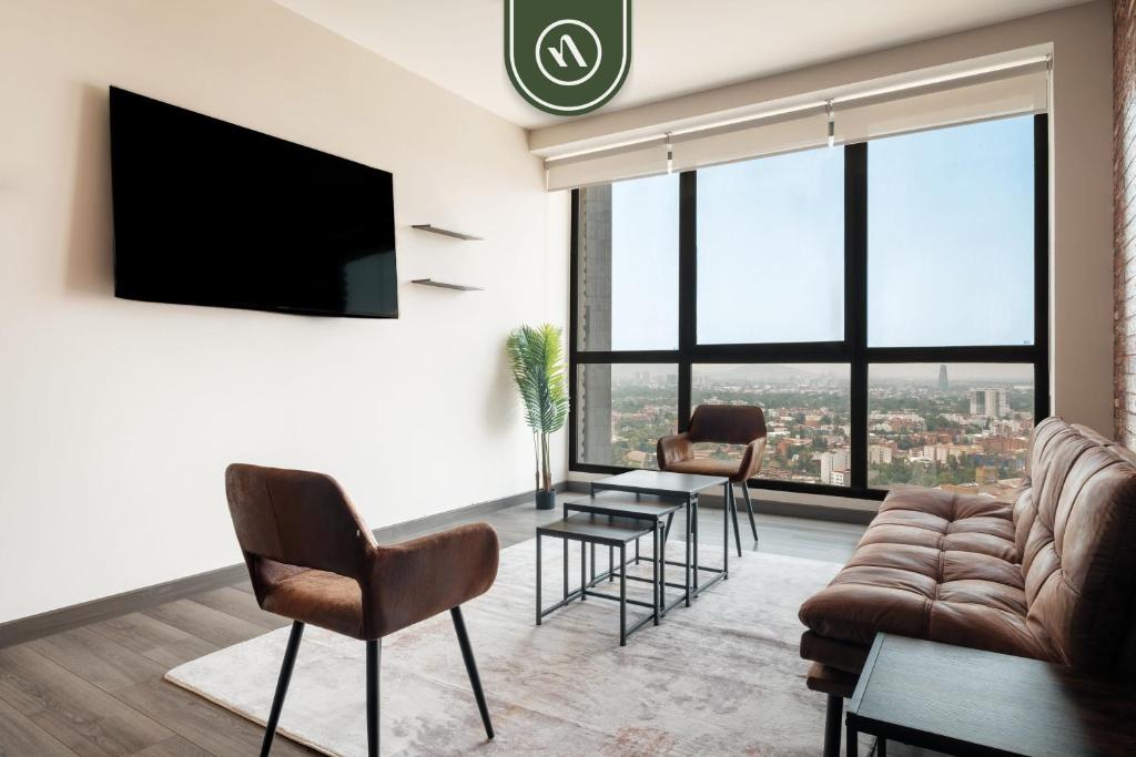 a living room with a couch and chairs and a tv at 1BR Condo in Polanco - Pool - Coworking - CityView in Mexico City