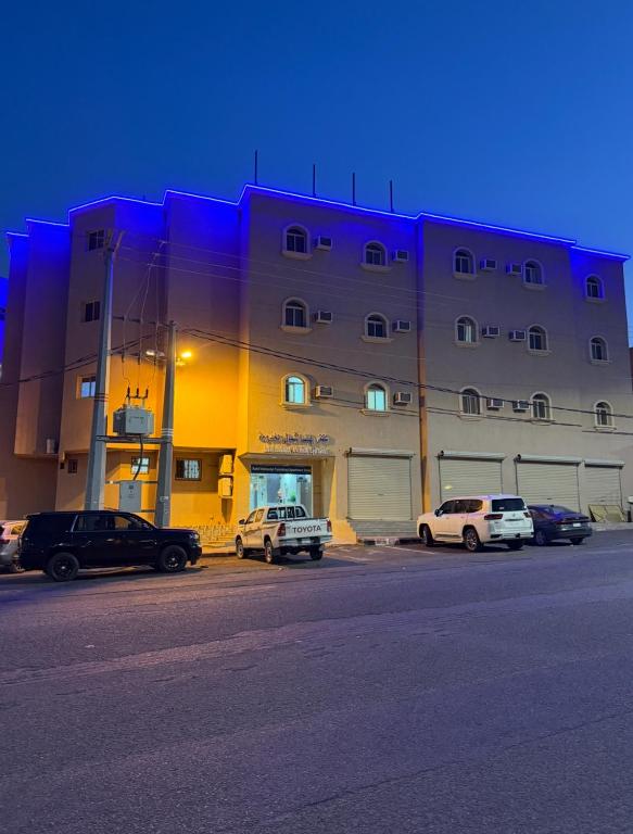 a large building with cars parked in front of it at شقق رفيف الشمال المخدومه - الحائط Alhayit -Rafeef Al Shamal رفيف الشمال شقق مخدومه - الحائط in Al Ḩāyiţ