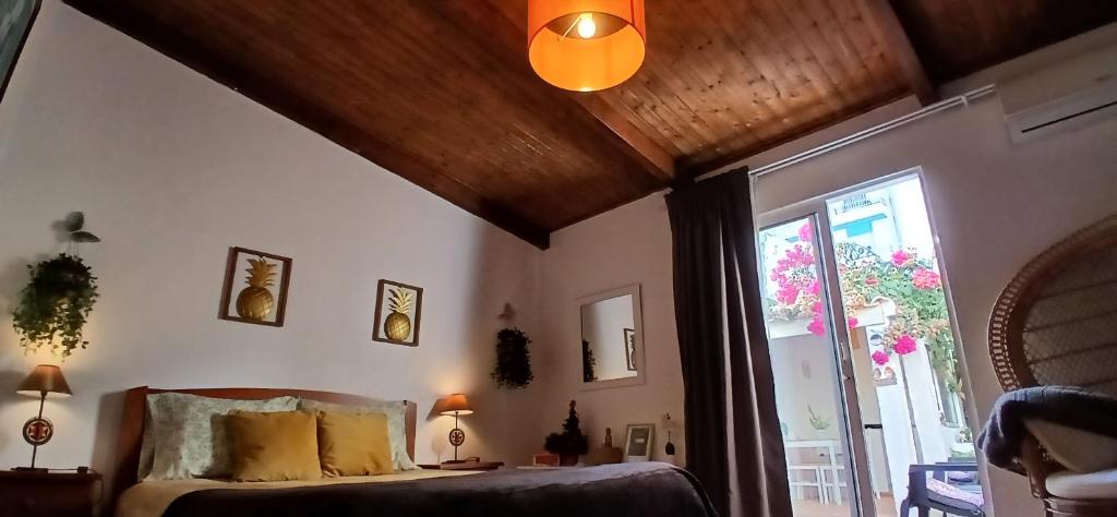 een slaapkamer met een bed en een groot raam bij Casa Rustica - Courtyard House in Olhão