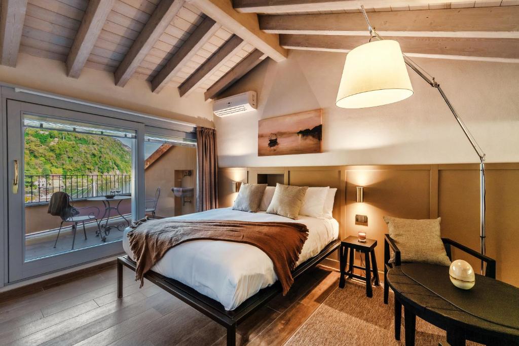 a bedroom with a bed and a large window at Home Holidays - by MyHomeInComo in Argegno