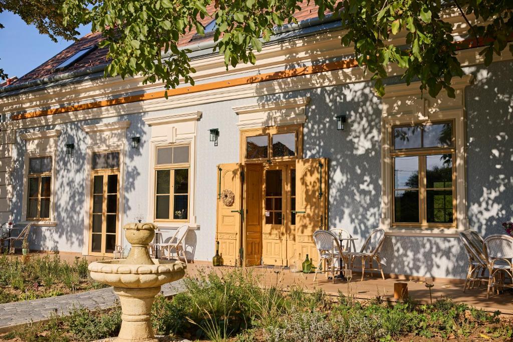 an old house with a fountain in front of it at Icce Borbirtok - Wine, Dine & Rest in Monoszló