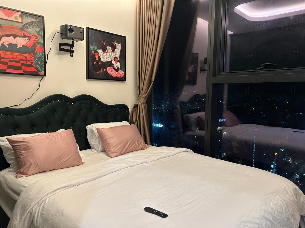 a bedroom with a bed with pink pillows and a window at 2-bedroom Doji apartment in hai phong in Hai Phong