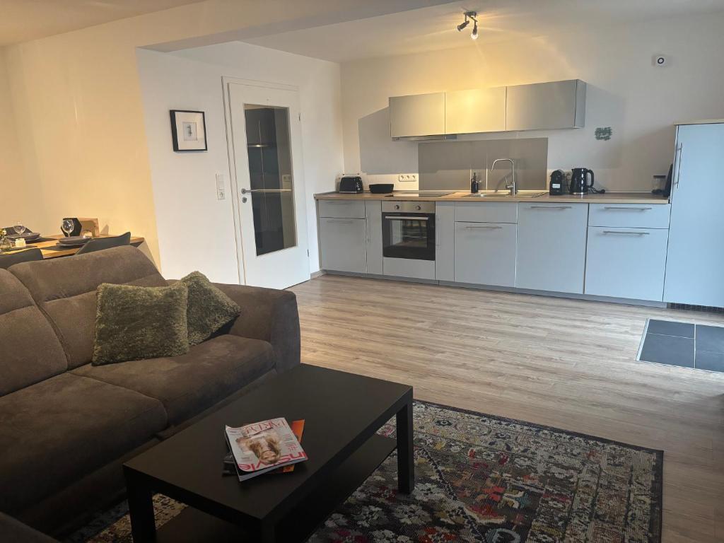 a living room with a couch and a kitchen at Ferienwohnung Am Sonnenrain in Albshausen