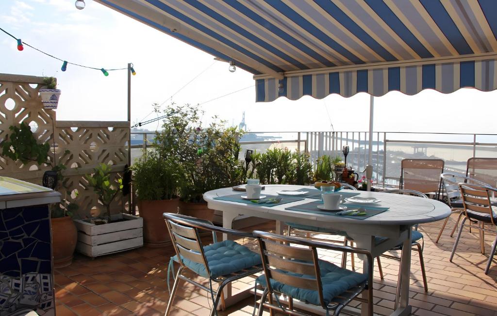 a table and chairs on a patio with a view at Chambre d'hôtes - Le quartier haut in Sète