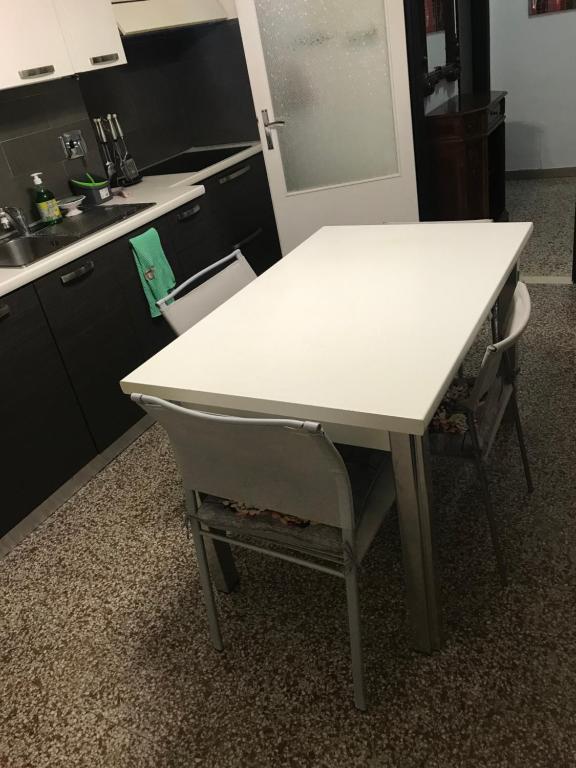 a white table and a chair in a kitchen at Via Clitunno 24 in Foligno